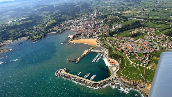 Luanco desde el aire, con el puerto y la playa