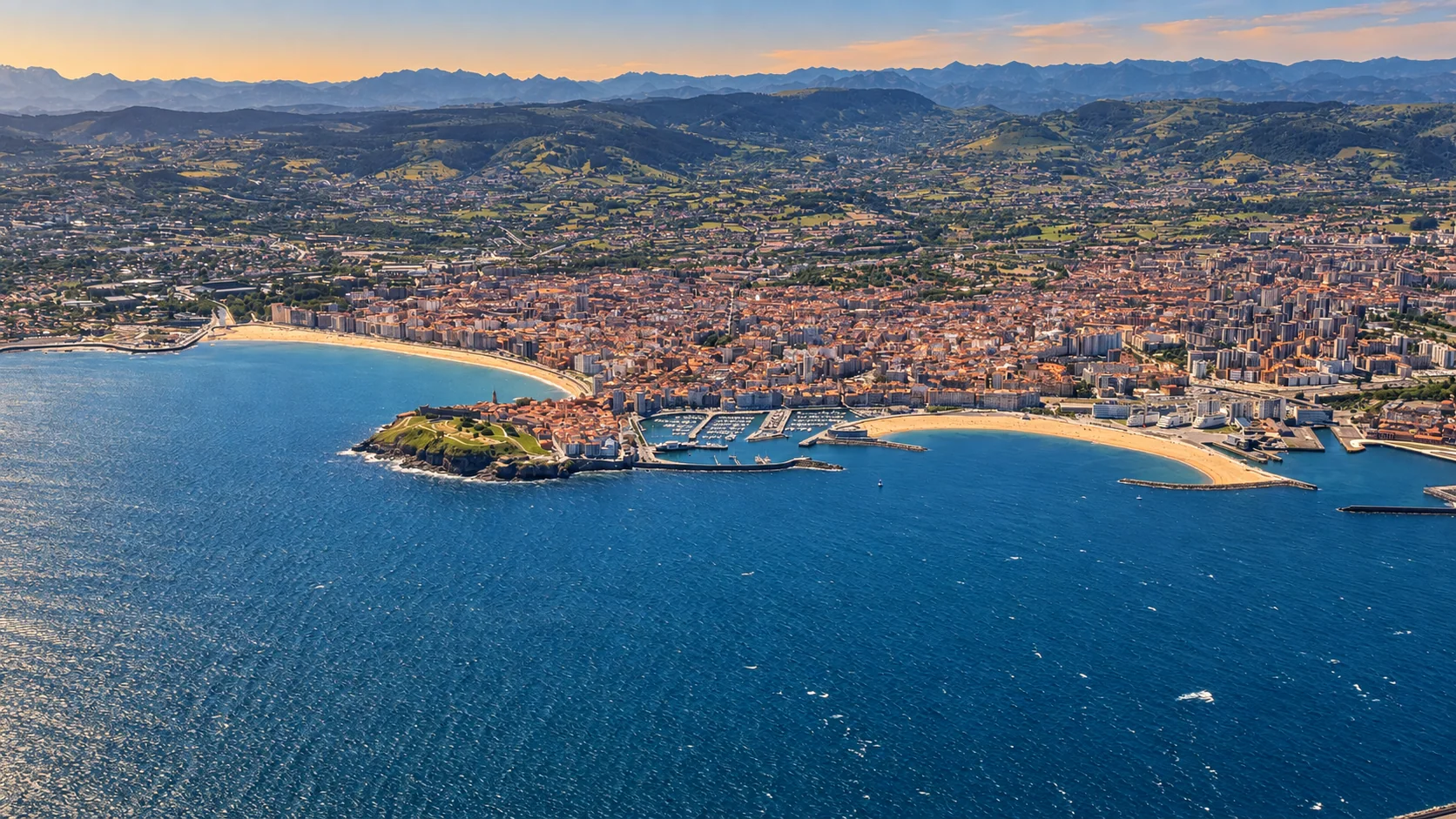 Gijón entero desde el aire, con la playa de San Lorenzo, el puerto deportivo y la isla